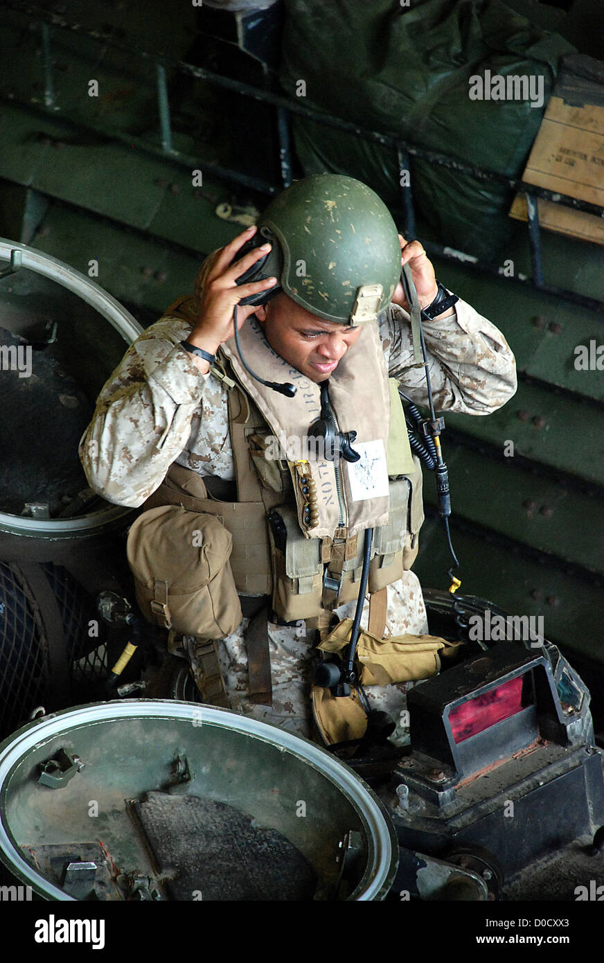 Staff Sgt Manuel Lennon dons einen Helm in eine amphibische Fahrzeug (AAV) an Bord Dock amphibischen Transportschiff USS Green Bay (LPD 20) während einer Übung Routine gut Deck. Green Bay ist Teil der Peleliu amphibische bereit Gruppe, mit th Stockfoto