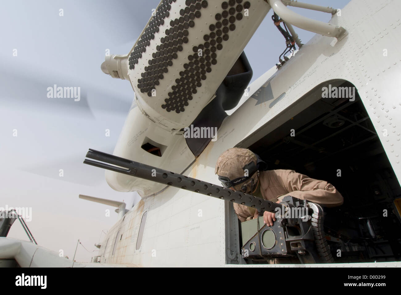 Eine US-Marine Tür-Schütze blickt aus einer CH-53D Sea Stallion von oben ein M2 Kaliber.50 Maschinengewehr Stockfoto