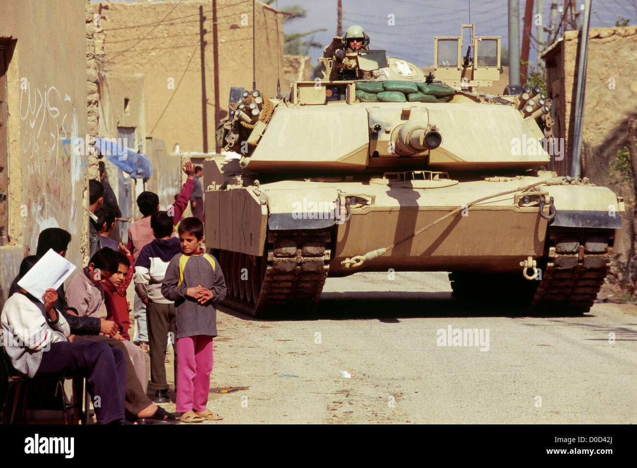 Kinder blicken auf einen vorbeifahrenden Marine Corps Tank während einer Kampfhandlung in Haqlaniyah, Irak Stockfoto