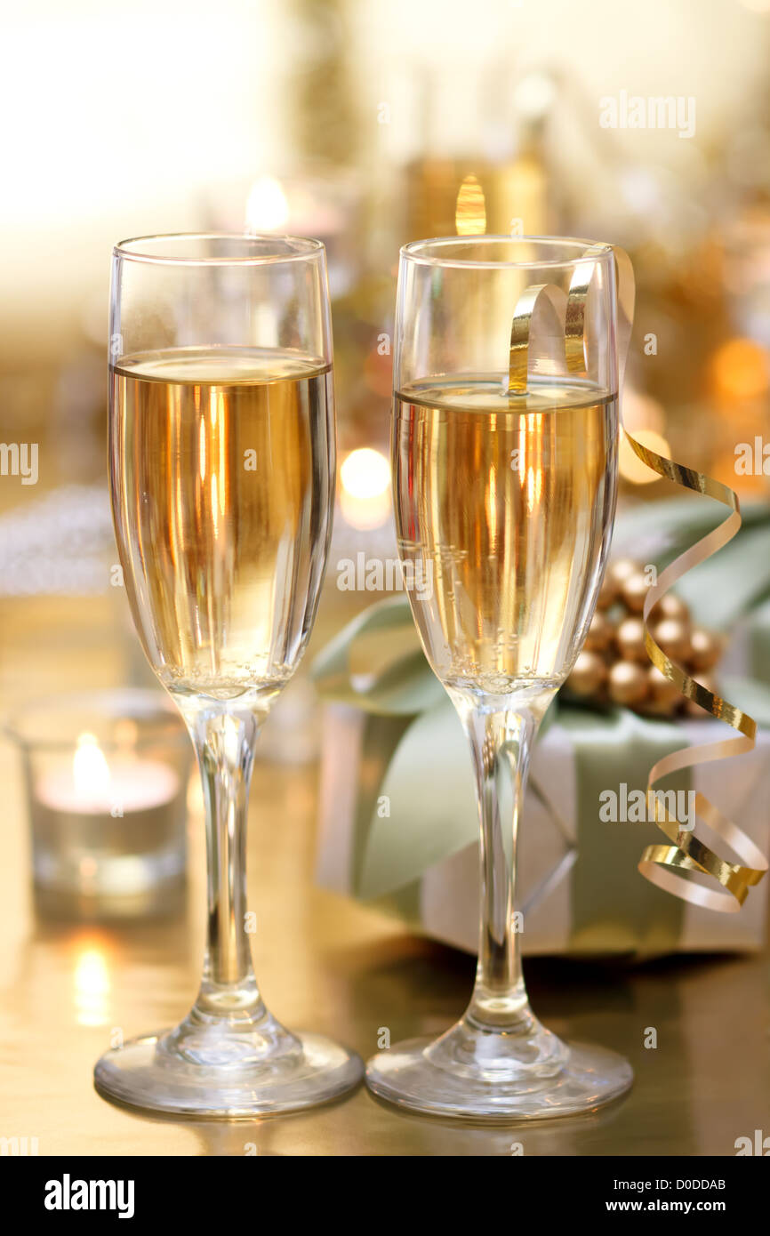 Leuchtendes Champagner Gläser mit Kerzen und Geschenke Stockfoto