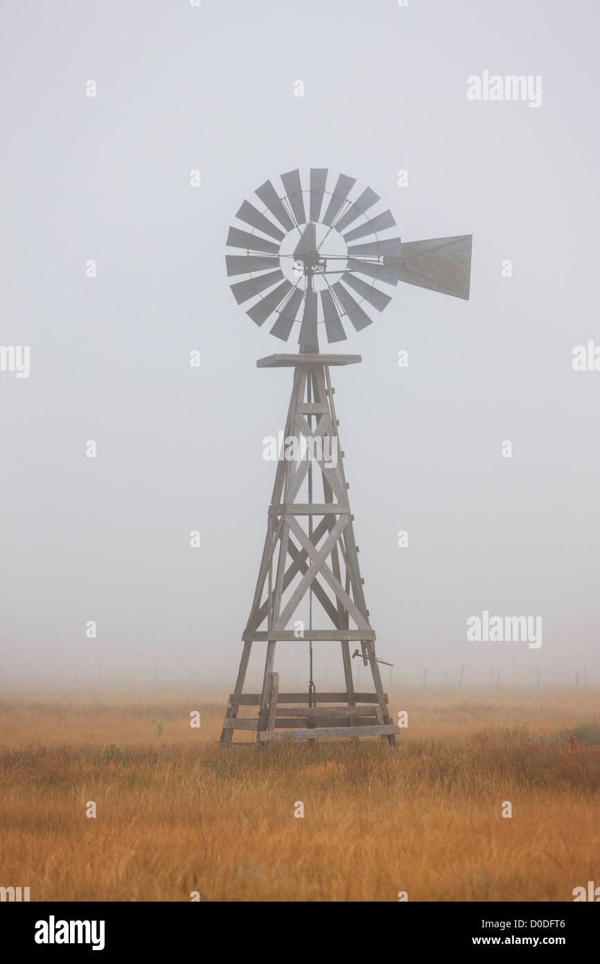 Eine Windmühle für Wasserpumpen teilweise eingehüllt von einer niedrigen Wolke östlichen Ebenen von Colorado. Stockfoto