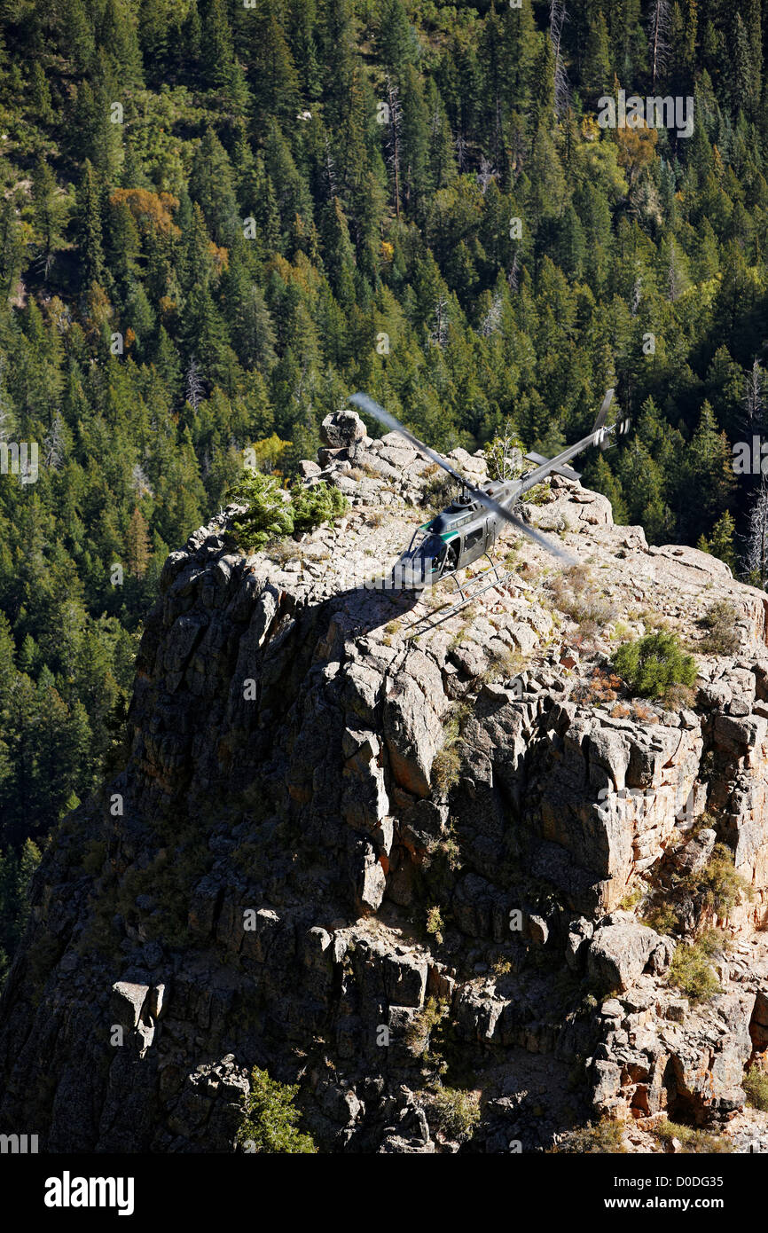 Ein OH-58 Kiowa im Leerlauf nach der Landung auf einem Stein-Turm in einen tiefen Canyon in Colorado Rocky Mountains. Stockfoto