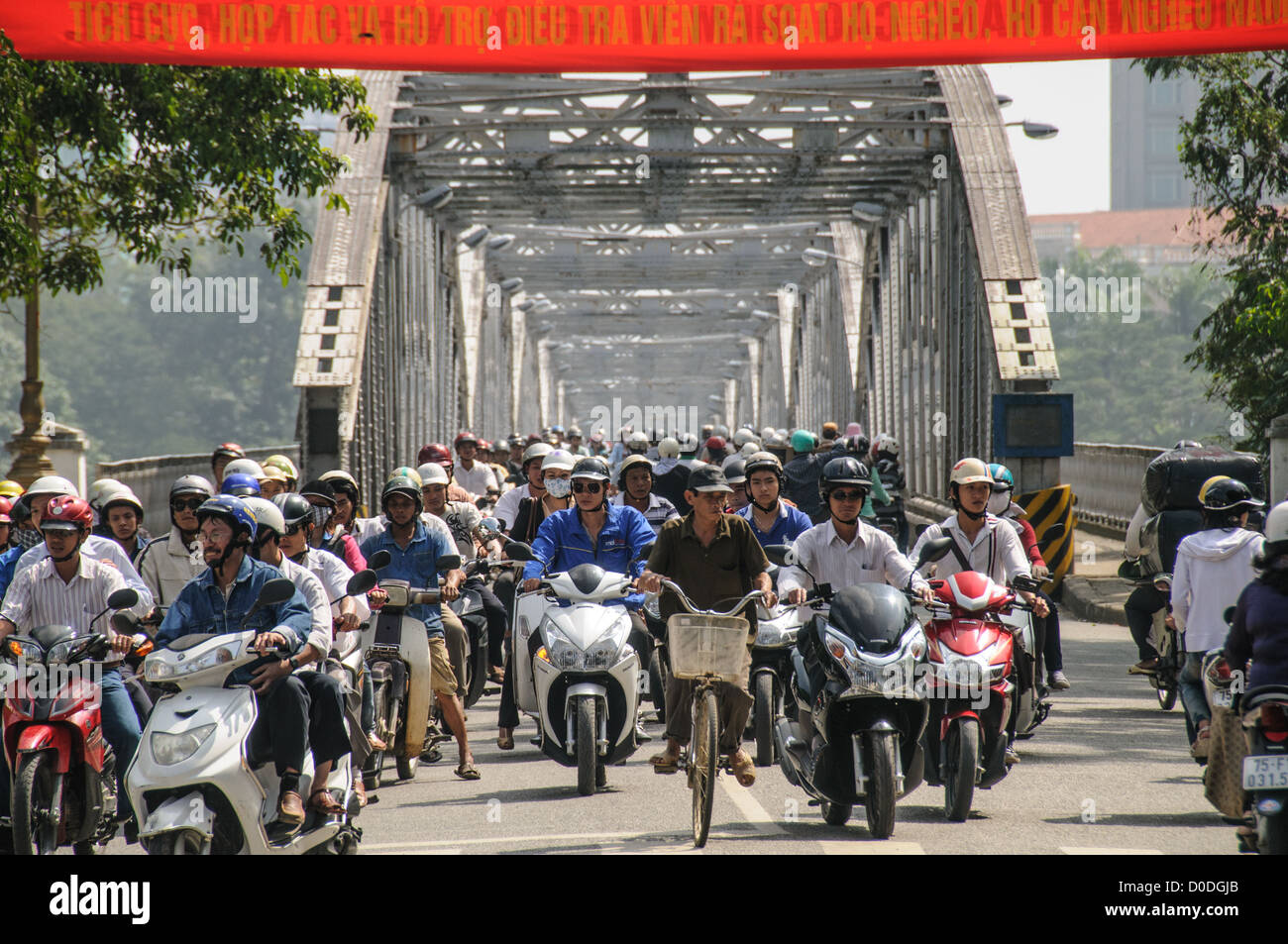 Motorroller und Fahrräder Verkehr Cau Truong Tien Bridge Hue Vietnam // Hunderte von Motorrollern und Fahrrädern überqueren Cau Truong Tien im Nachmittagsverkehr in Hue, Vietnam. Stockfoto