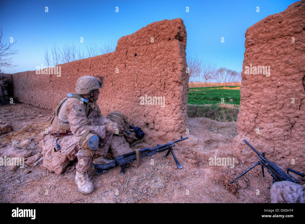 United States Marine hinter der Abdeckung ein Schlamm-Mauer während einer Kampfhandlung in der afghanischen Provinz Helmand Stockfoto