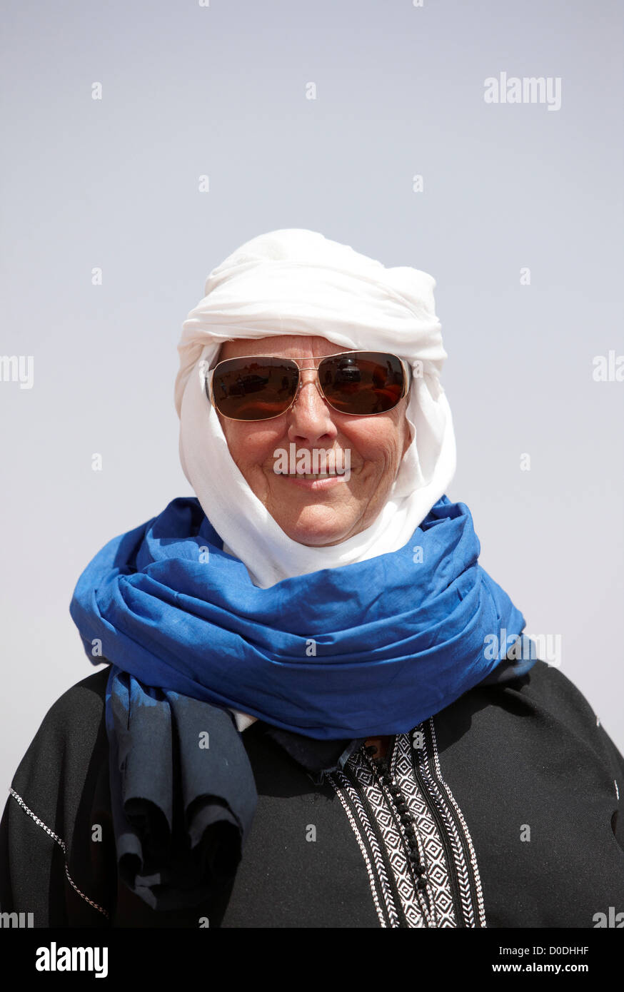 Weibliche französische Touristen tragen eine Sahara Gandora, einen Turban und eine Burnoose, Mhamid, Marokko. Stockfoto