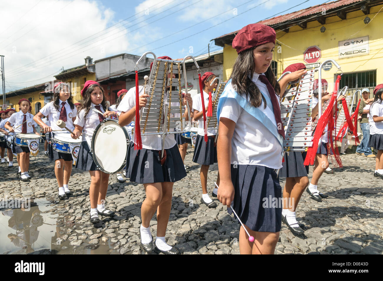 Schulmarschband Unabhängigkeitsparade Antigua Guatemala // am Vormittag am Tag vor dem Unabhängigkeitstag Guatemalas (der am 15. September gefeiert wird) marschieren Hunderte Schulkinder aus Antigua und den umliegenden Dörfern in Antigua zu einer Parade von Schulgruppen, einige in Kostümen und andere in Schuluniformen. Die Parade umfasst auch Schulmarschbands und Cheerleader. Die Prozession beginnt am Parque Central und schlängelt sich vorbei an der leuchtend gelben Kirche La Merced in das Stadion der Stadt. Stockfoto