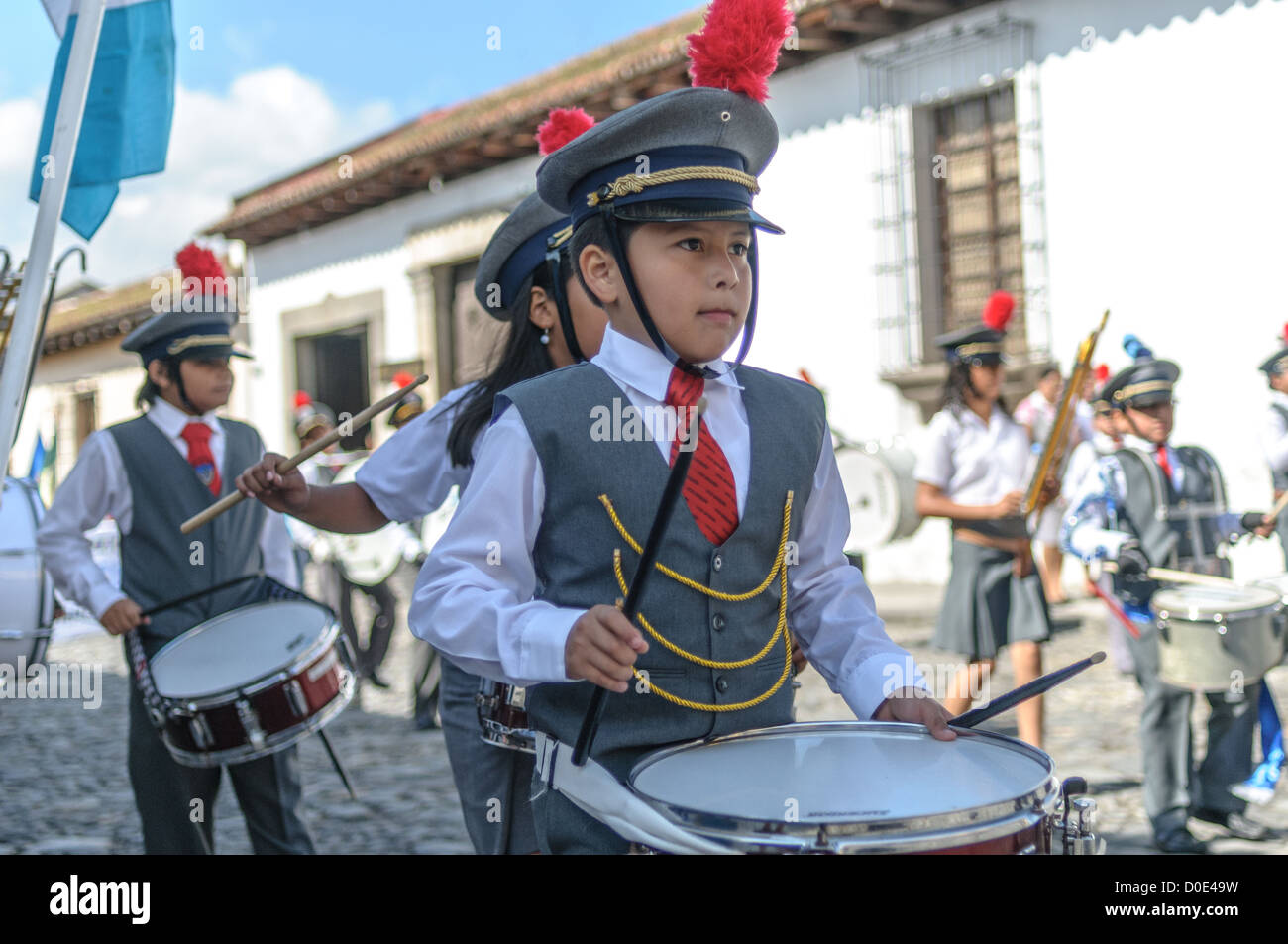 Guatemaltekische Unabhängigkeitstag Parade Schule Marching Band Antigua Guatemala // am Vormittag am Tag vor dem Tag der Unabhängigkeit Guatemalas (der am 15. September gefeiert wird) marschieren Hunderte Schulkinder aus Antigua und den umliegenden Dörfern in einer Parade von Schulgruppen in Antigua, einige in Kostümen und andere in Schuluniformen. Die Parade umfasst auch Schulmarschbands und Cheerleader. Die Prozession beginnt am Parque Central und schlängelt sich vorbei an der leuchtend gelben Kirche La Merced in das Stadion der Stadt. Stockfoto