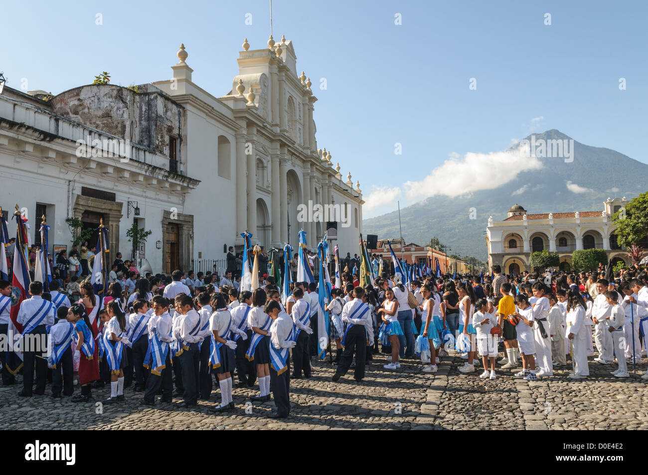 Parade zum Unabhängigkeitstag von Guatemala Schulkindern Antigua Guatemala // am Vormittag am Tag vor dem Unabhängigkeitstag Guatemalas (der am 15. September gefeiert wird) marschieren Hunderte Schulkinder aus Antigua und den umliegenden Dörfern zu einer Parade von Schulgruppen in Antigua, einige in Kostümen und andere in Schuluniformen. Die Parade umfasst auch Schulmarschbands und Cheerleader. Die Prozession beginnt am Parque Central und schlängelt sich vorbei an der leuchtend gelben Kirche La Merced in das Stadion der Stadt. Stockfoto