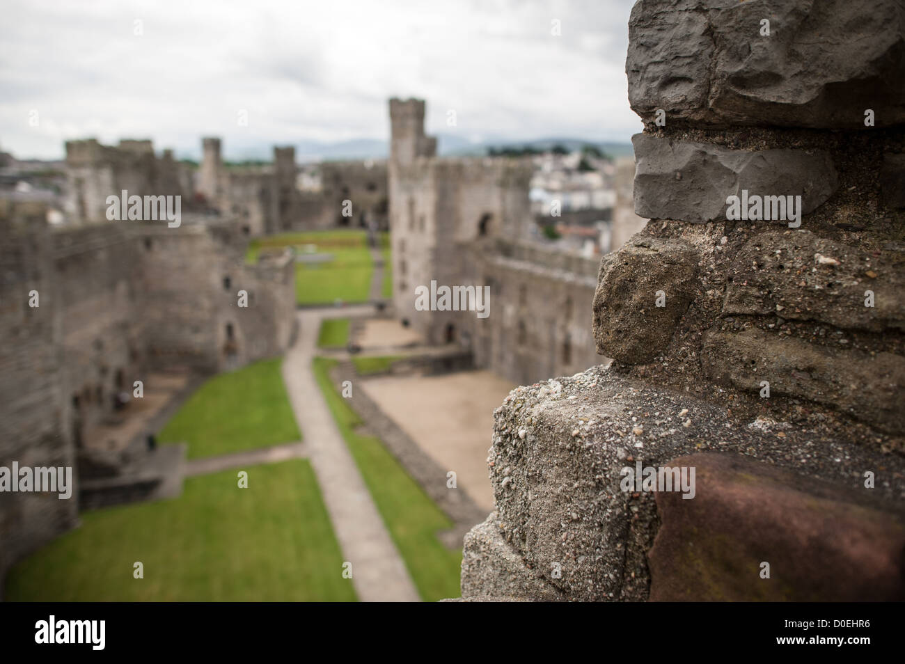 CAERNARFON, Wales – Steinmauern auf Caernarfon Castle im Nordwesten von Wales. Ursprünglich stand an der Stelle eine Burg aus dem späten 11. Jahrhundert, aber im späten 13. Jahrhundert ließ König Eduard I. ein neues Gebäude in Auftrag geben, das bis heute besteht. Es hat markante Türme und ist eines der am besten erhaltenen Burgen der Reihe, die Edward I. in Auftrag gab. Stockfoto