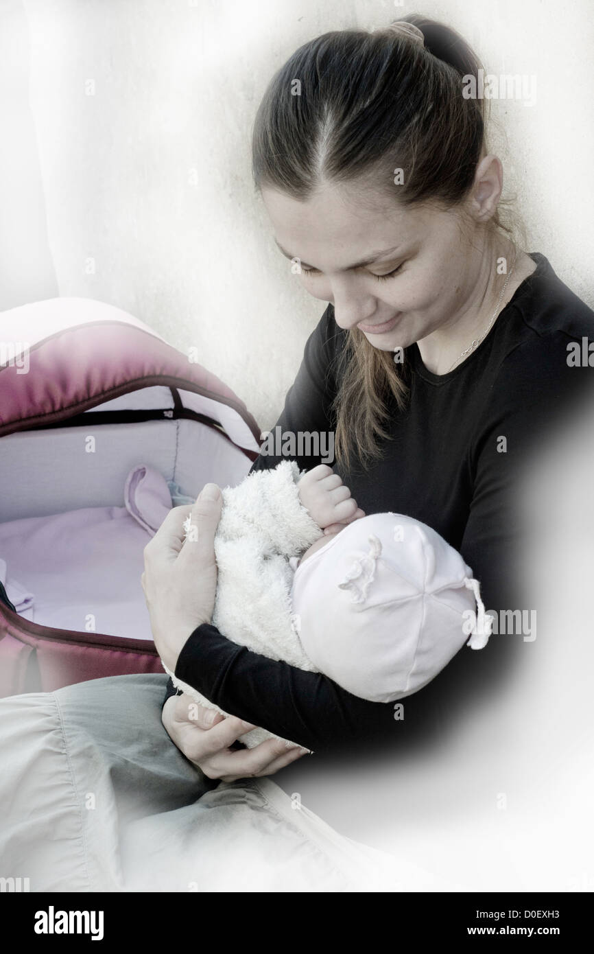 Glückliche Mutterschaft, Mutter wiegt Baby. Sozialfotografie. Stockfoto