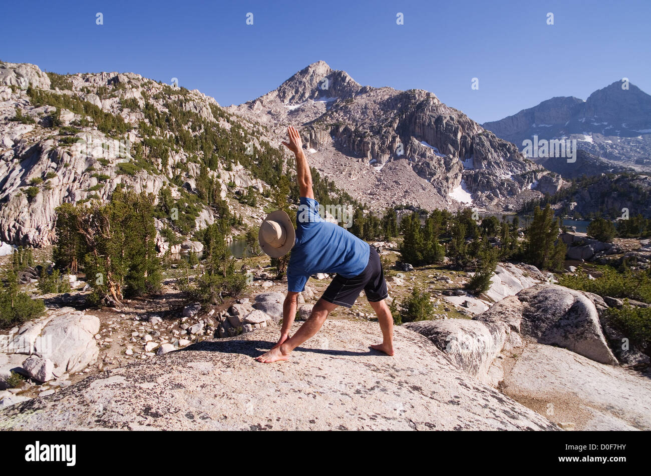 ein Mensch tut, das Yoga Dreieck-Pose oder Trikanasana in der Natur Stockfoto