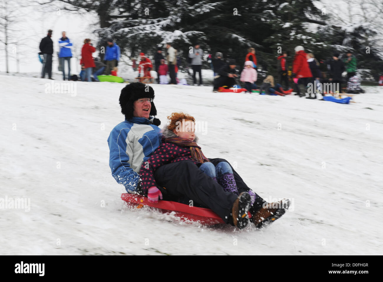 Vater und Tochter Schlitten im Schnee in Greenwich Park London uk Stockfoto