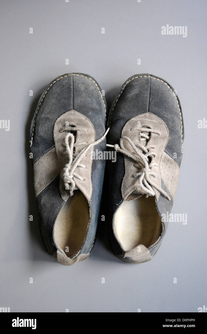 alte Schuhe in einem grauen Hintergrund, alte Schnürsenkel, Schuhe  abgenutzt, alt Stockfotografie - Alamy