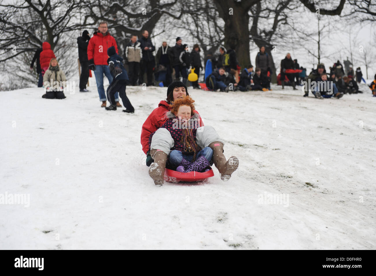 Vater und Tochter Schlitten im Schnee in Greenwich Park London uk Stockfoto