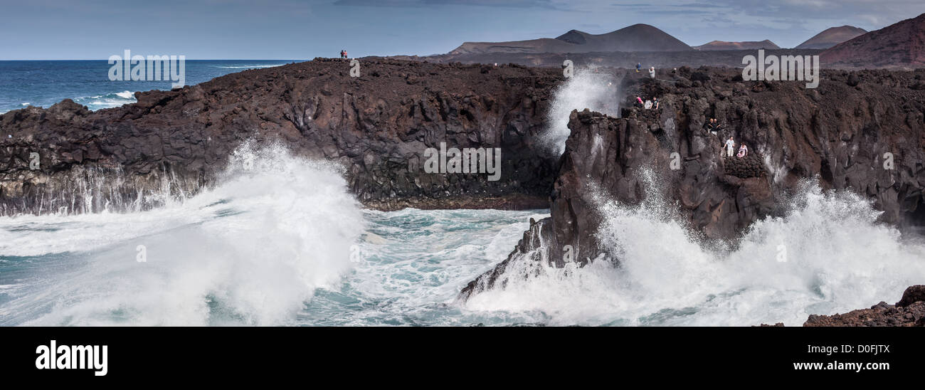 Touristen sehen Los Hervideros eine Reihe von Höhlen und Schlaglöchern auf Lanzarote, Kanarische Inseln Stockfoto