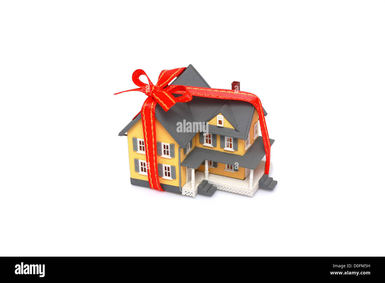 Geschenk-Miniatur-Haus mit Ed Band isoliert auf weißem Hintergrund Stockfoto