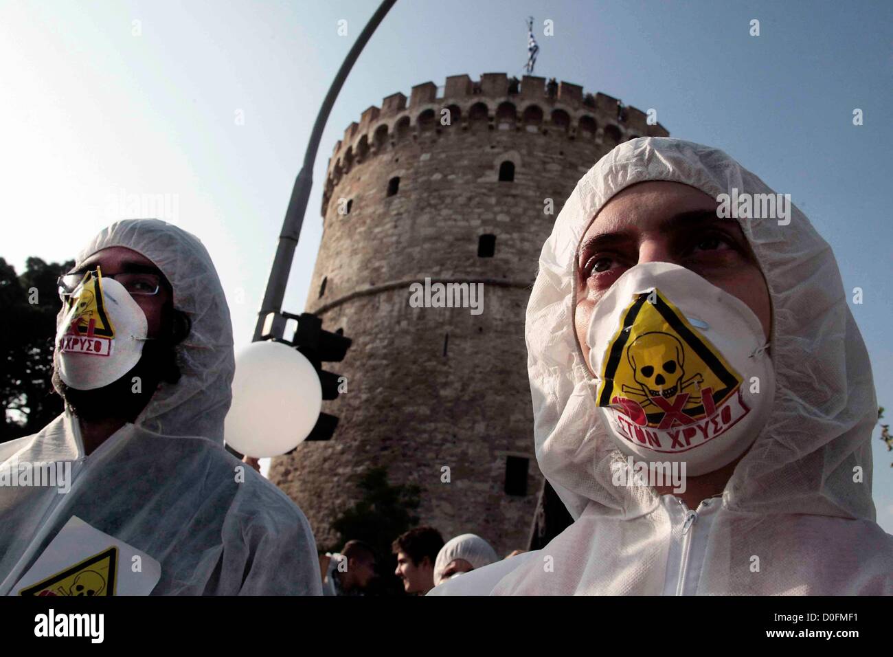 Schutzanzüge und Masken tragen Demonstranten marschieren durch die Straßen während einer Demonstration in Thessaloniki, Griechenland am 24.11.2012. Die Demonstranten protestieren gegen ein gold-Mining-Projekt von Hellas Gold, eine Tochtergesellschaft der kanadischen Gesellschaft Eldorado Gold, das in Skouries Halkidiki geplant ist. Stockfoto