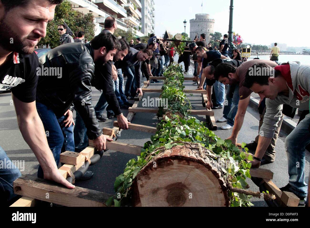 Demonstranten tragen gefällte Bäume durch die Stadt während einer Demonstration am 24.11.2012 in Thessaloniki, Griechenland. Die Demonstranten protestieren gegen ein gold-Mining-Projekt von Hellas Gold, eine Tochtergesellschaft der kanadischen Gesellschaft Eldorado Gold, das in Skouries Halkidiki geplant ist. Stockfoto