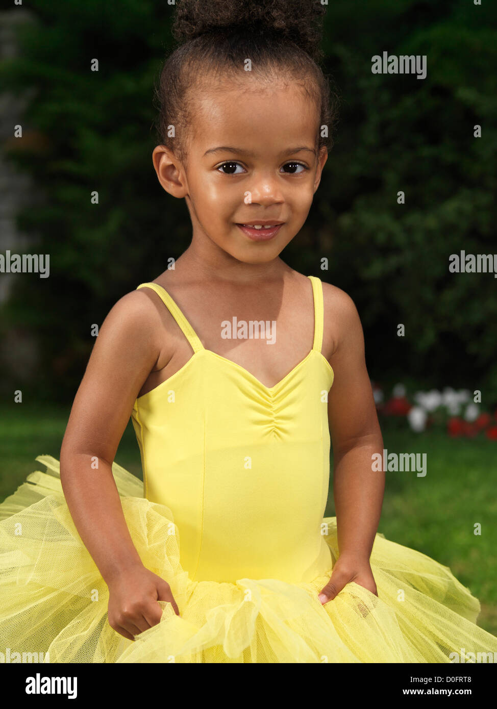Porträt von einem netten Lächeln auf den Lippen drei Jahre alte schwarze Mädchen trägt eine gelben Tutu-Kleid Stockfoto