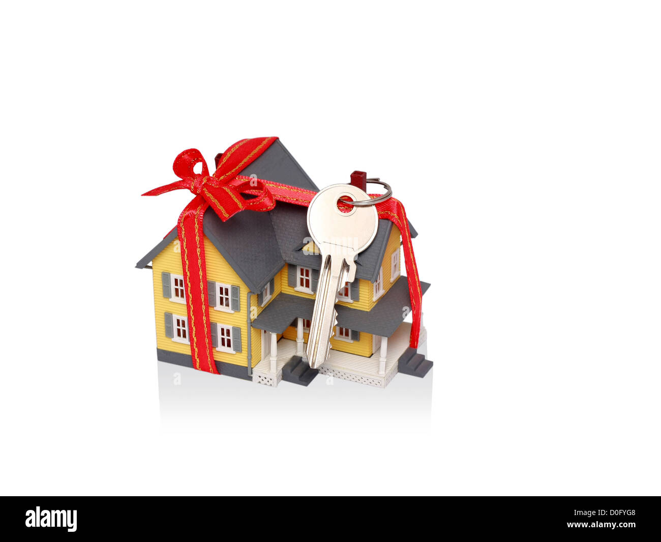 Geschenk Miniaturhaus mit rotem Band und Schlüssel isoliert auf weißem Hintergrund - einschließlich Beschneidungspfad Stockfoto