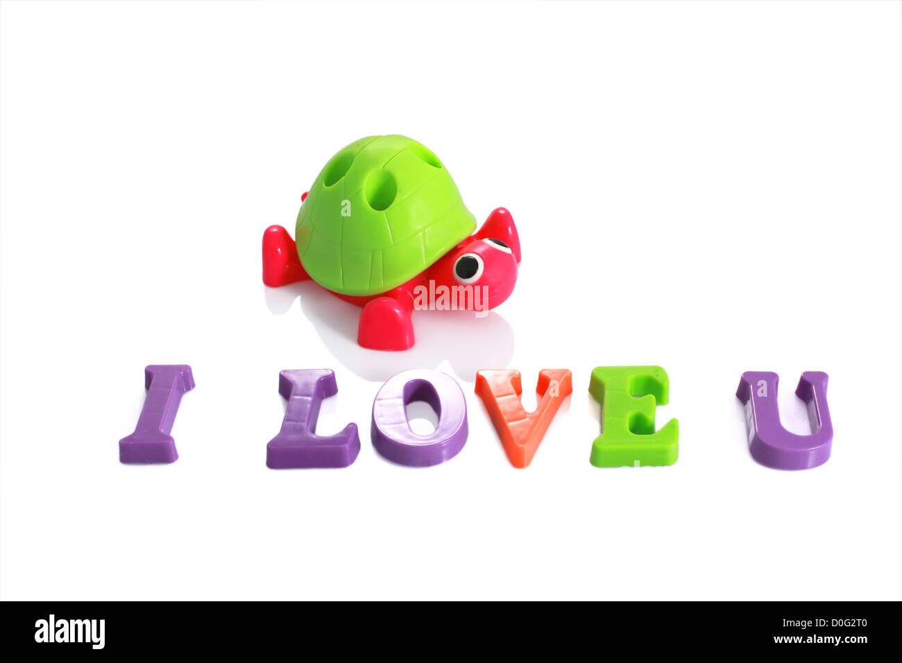 Spielzeug-Schildkröte mit Text ich liebe dich geschrieben von Kunststoff Buchstaben auf weißem isoliert Stockfoto