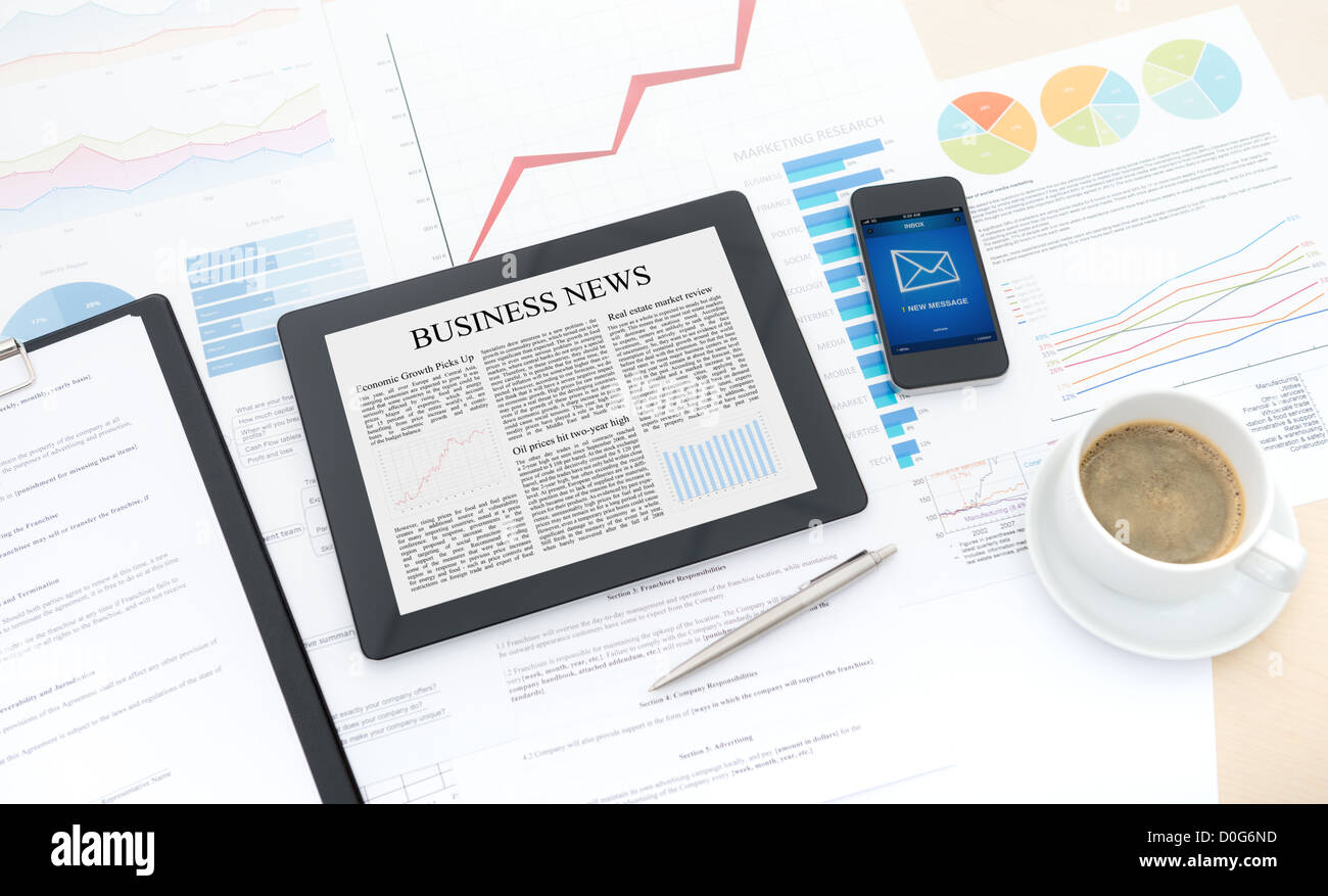 Moderne Business-Workflow mit digitalen Computer, Handy und einige Papiere mit Grafiken und Zahlen auf einem Desktop. Stockfoto