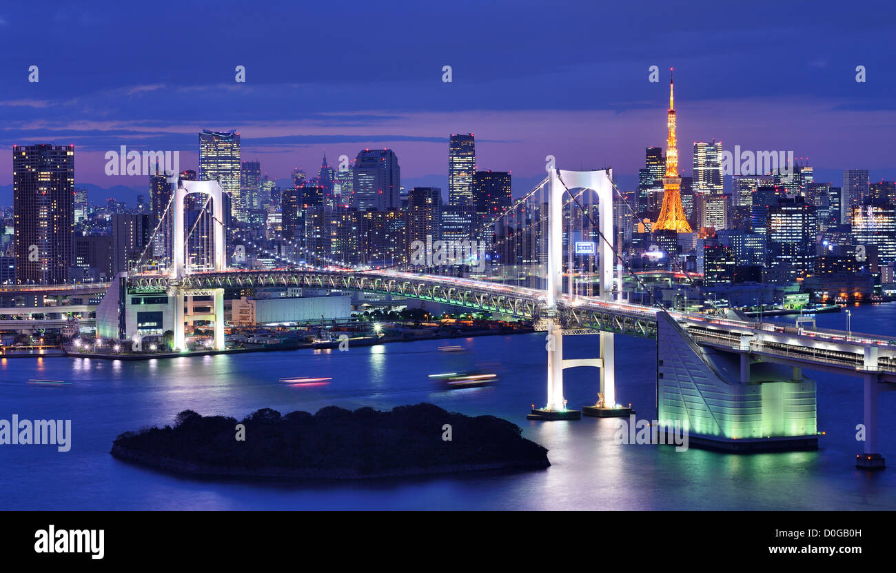 Rainbow Bridge überspannt die Bucht von Tokio mit Tokyo Tower im Hintergrund sichtbar. Stockfoto