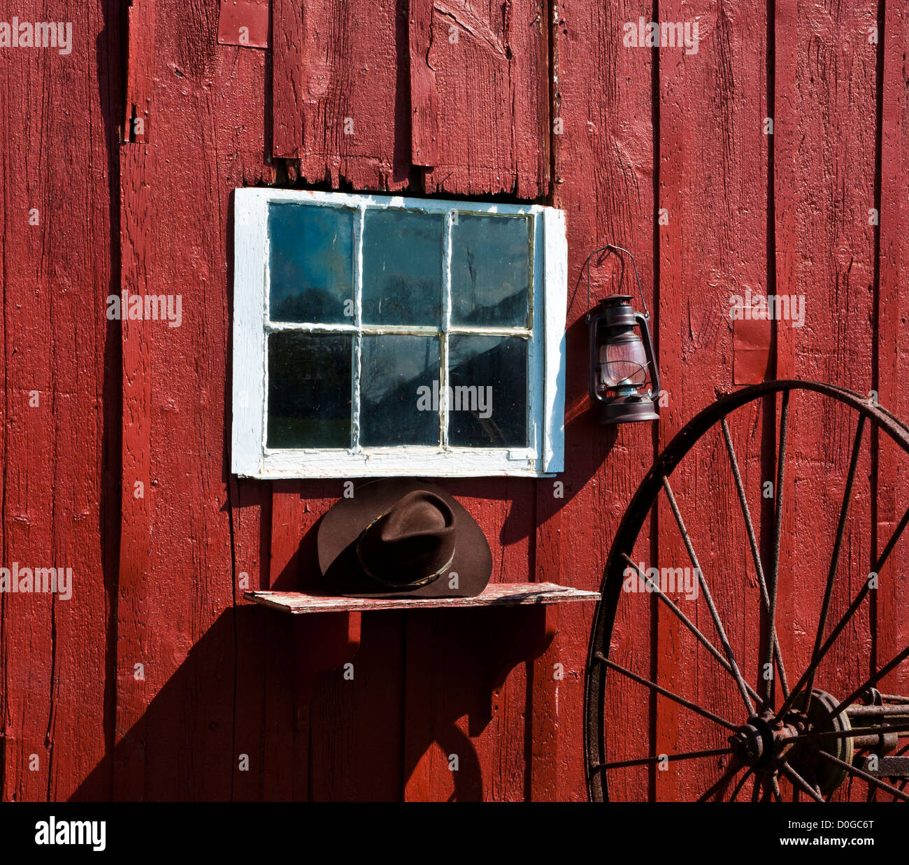 Rote Scheune, Vintage Fensterbank ungewöhnliche Nahaufnahme mit einem Cowboy Hut, alte Laterne und Heuhake Rad abstrakt, NJ, USA, U USA, Vintage Öllampe Stockfoto