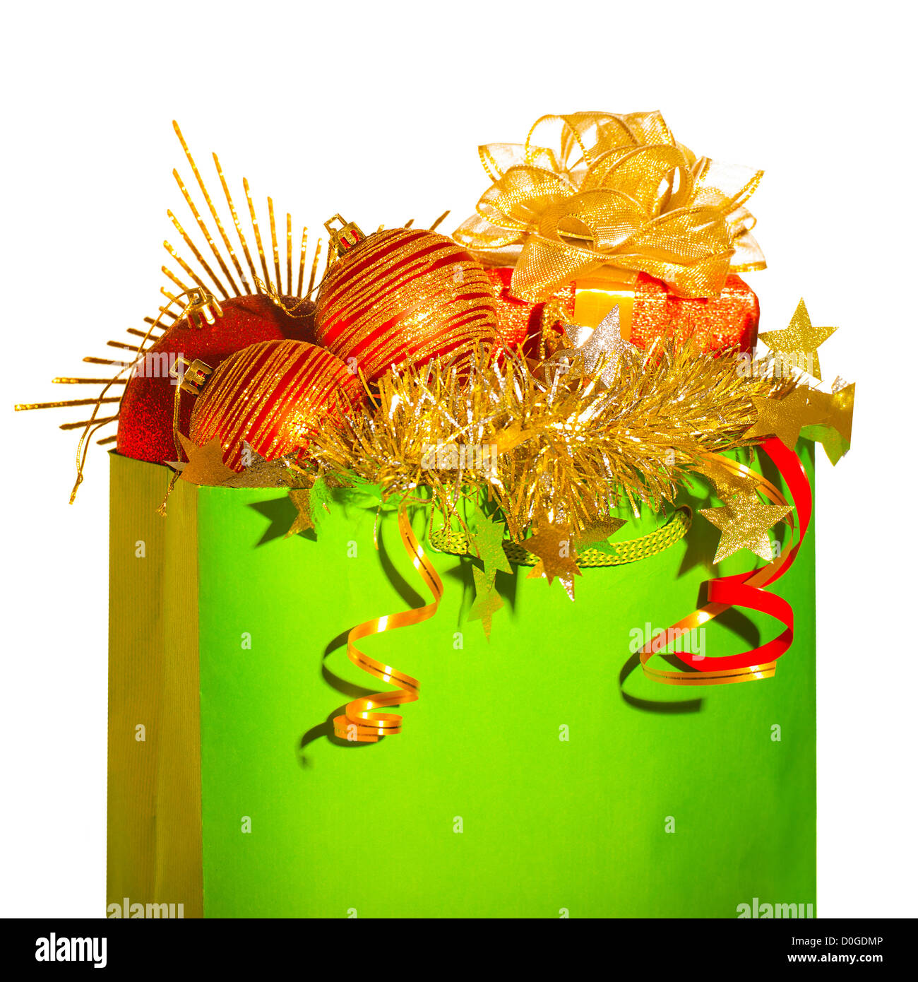 Foto von traditionellen Weihnachtsbaum Dekoration, grüne Einkaufstasche voller festliche Spielzeug und Geschenke isoliert Stockfoto