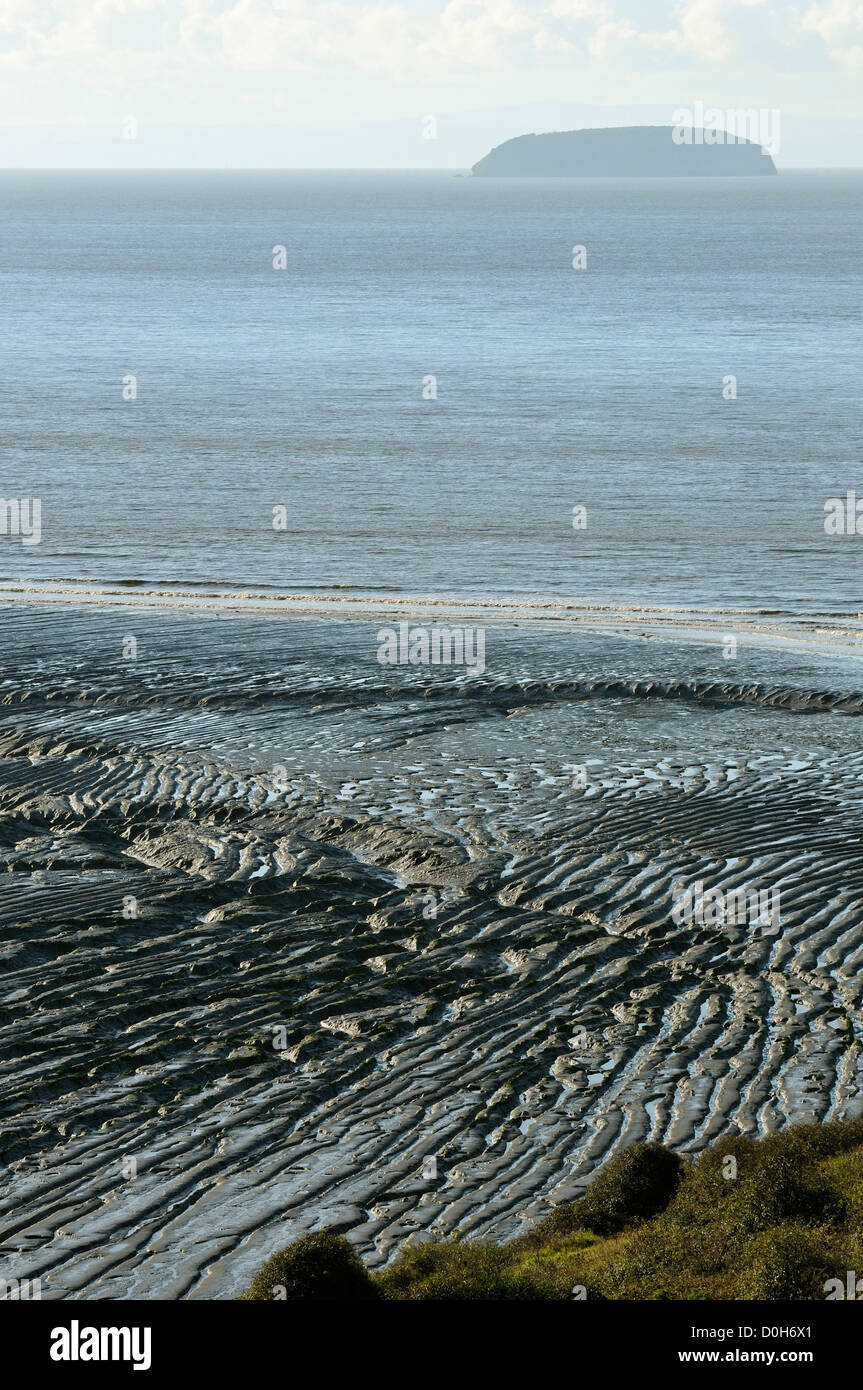 Schlamm Wellen im Sand-Bucht mit steilen Holm hinter Stockfoto
