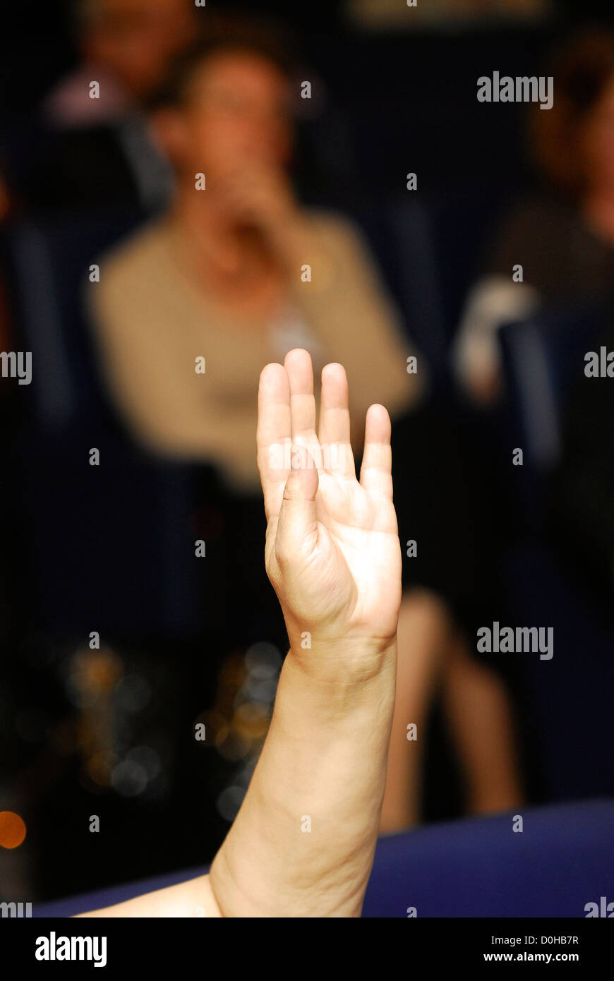 Delegieren an einem pflegepersonen Konferenz mit der Hand angehoben Aufmerksamkeit während Frage & Antwort Sitzung, London, UK. Stockfoto