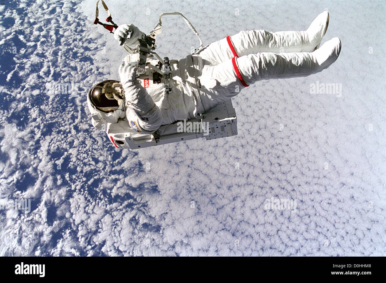 Backdropped gegen Wolken 130 Seemeilen unten schwebt Astronaut Mark frei ohne Tether wie er die neue SIM-Karte testet Stockfoto