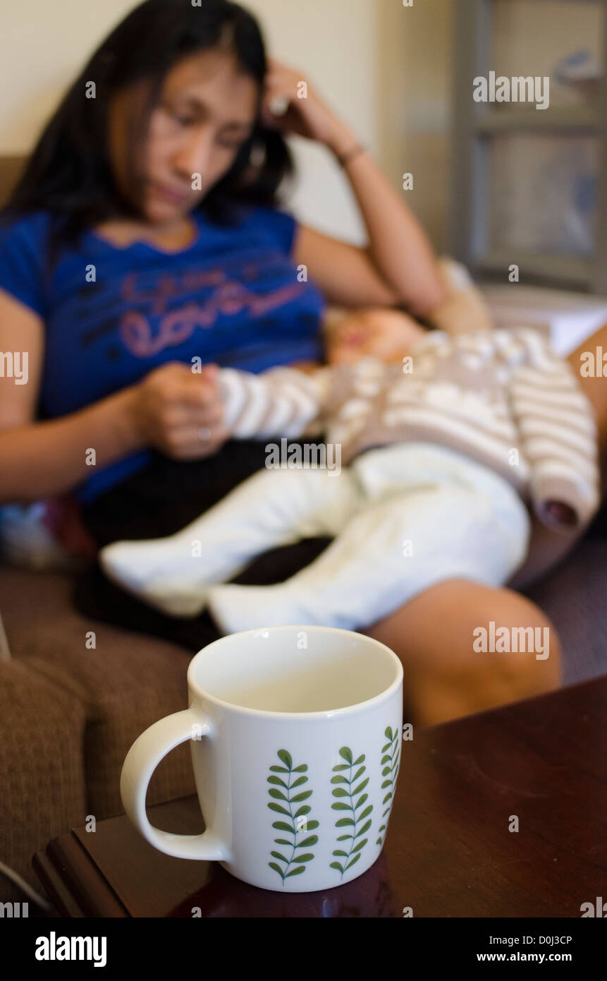 müde Mama schlafen im Stuhl Stockfoto