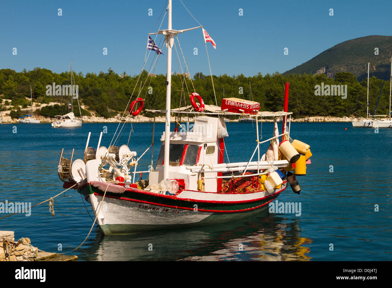 Rote und weiße Fischerboot vor Anker bei Fiscardo, Kefalonia, Griechenland Stockfoto