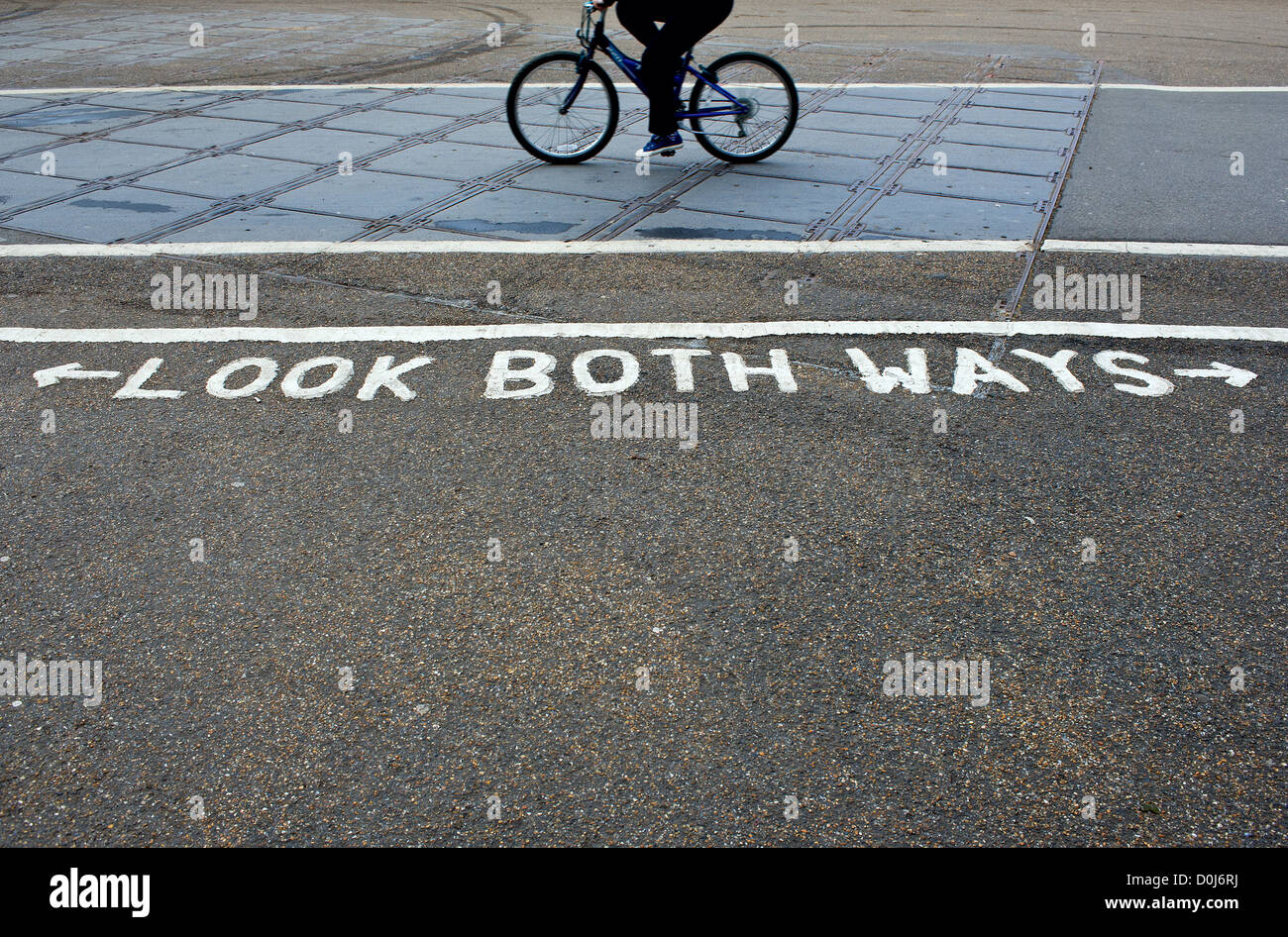 Ein Radfahrer vorbei ein Zeichen auf den Boden gemalt. Stockfoto