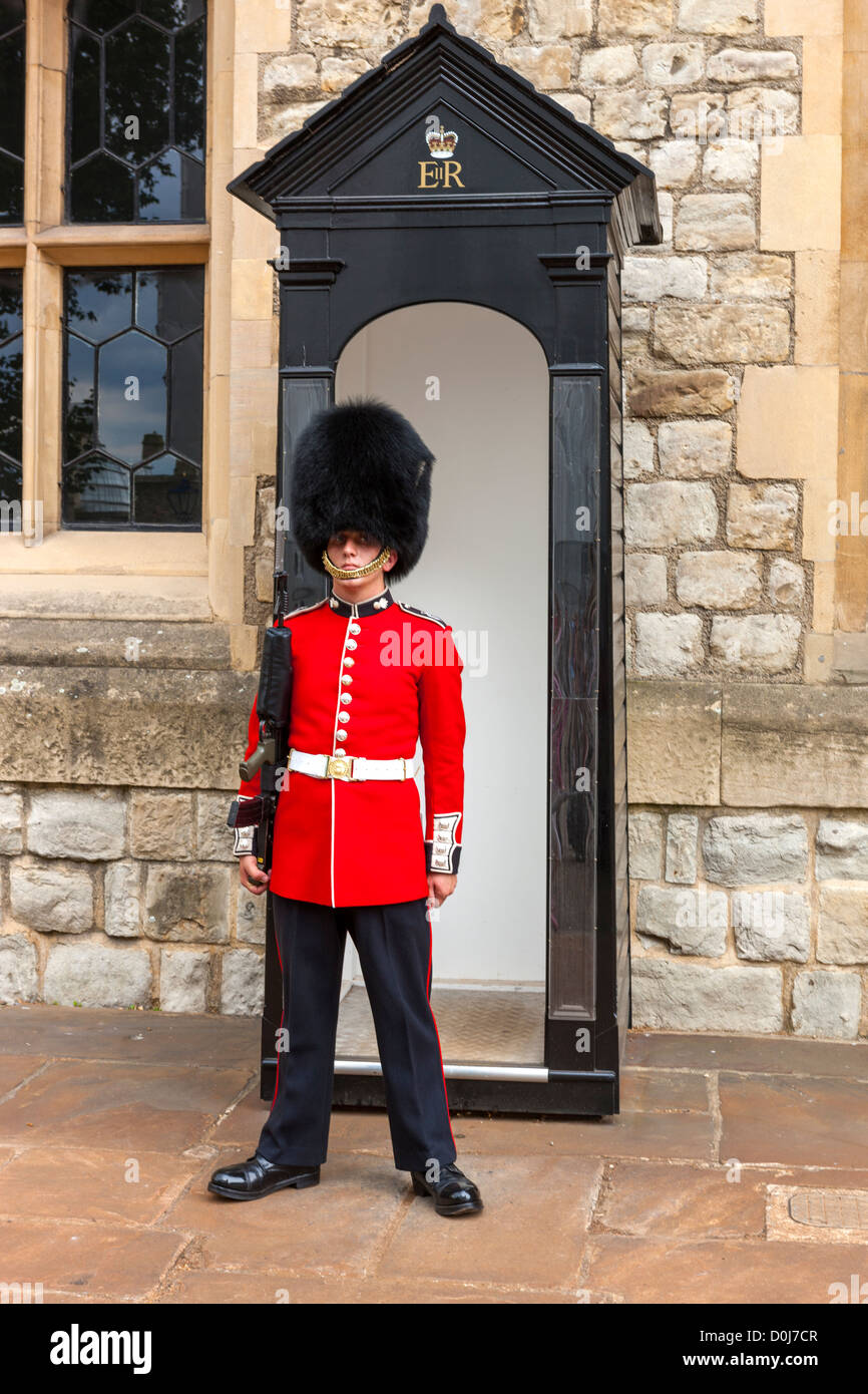 Eine Wache tragen traditionelle Bärenfell steht Wache vor dem Juwel-Haus in den Tower of London, London, England. Stockfoto