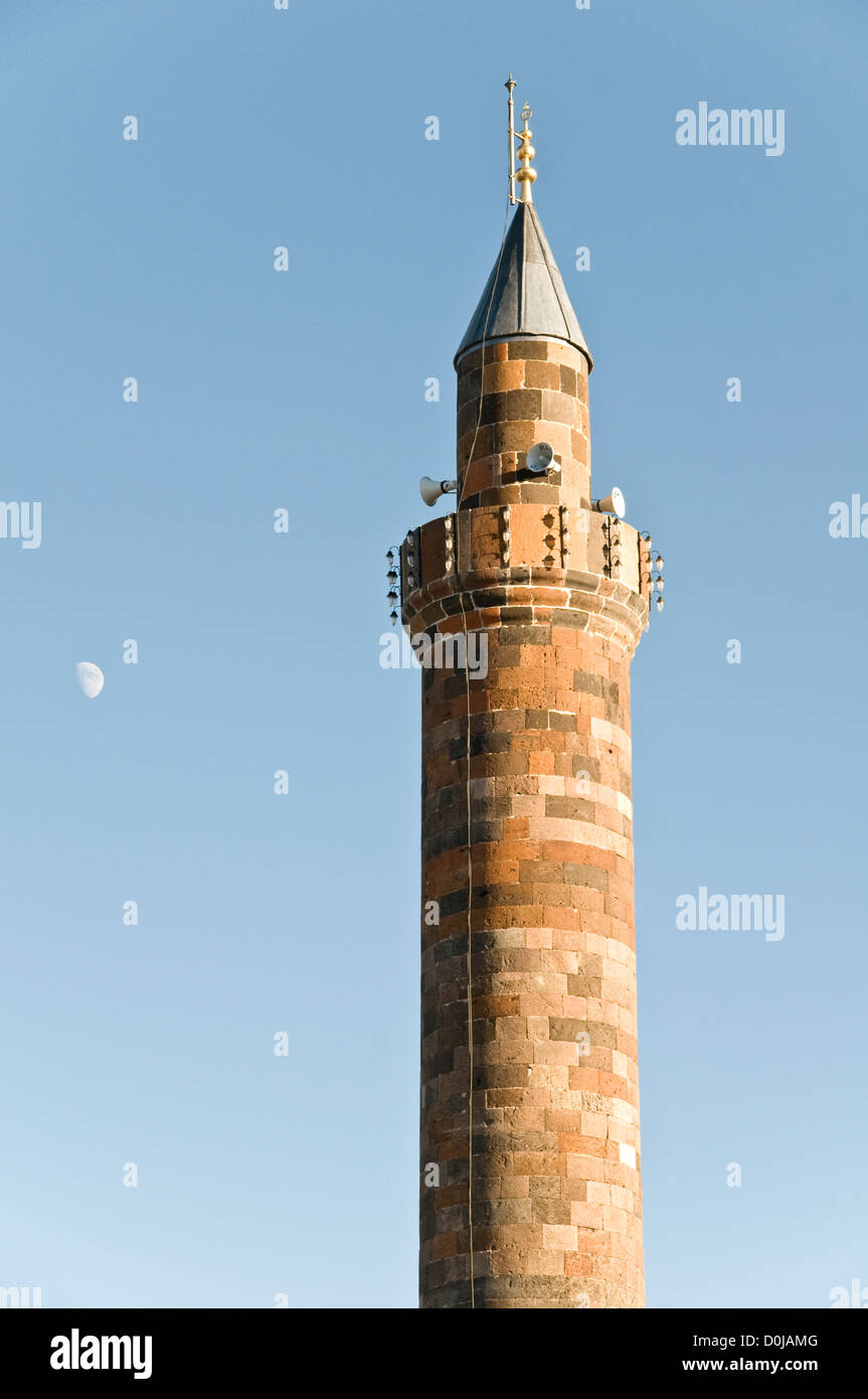 Ein buntes altes Minarett einer osmanischen Moschee und des Mondes in der türkischen Stadt Kars, im östlichen Anatolien im Nordosten der Türkei. Stockfoto
