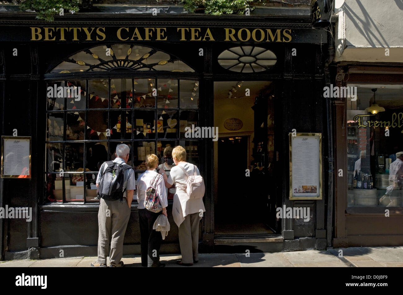 Menschen suchen im Fenster des kleinen Bettys Café und Tee Zimmer in Stonegate. Stockfoto