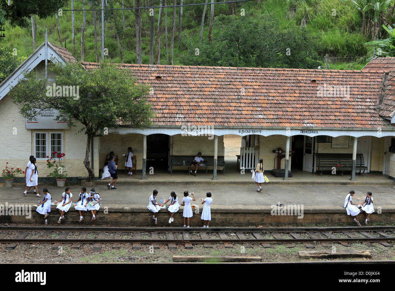Schulkinder in Uniform am Demodara Bahnhof in der Nähe von Ella im Hochland von Sri Lanka. Stockfoto