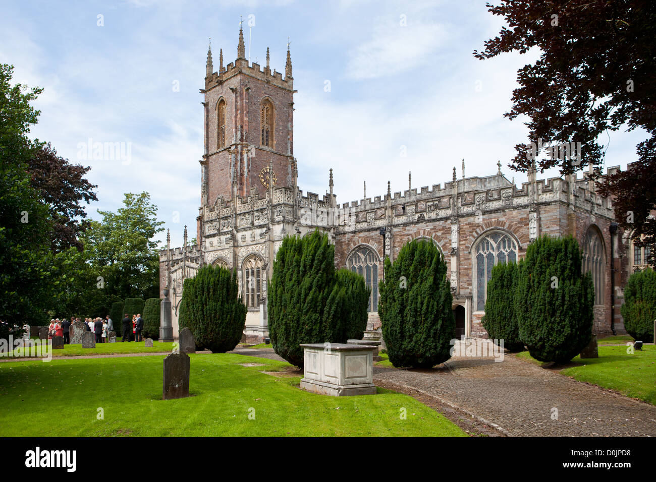 Tiverton, Großbritannien: Ein Grab in dem Garten des Heiligen Petrus Pfarrkirche. Im Hintergrund ist eine Trauung statt. Stockfoto