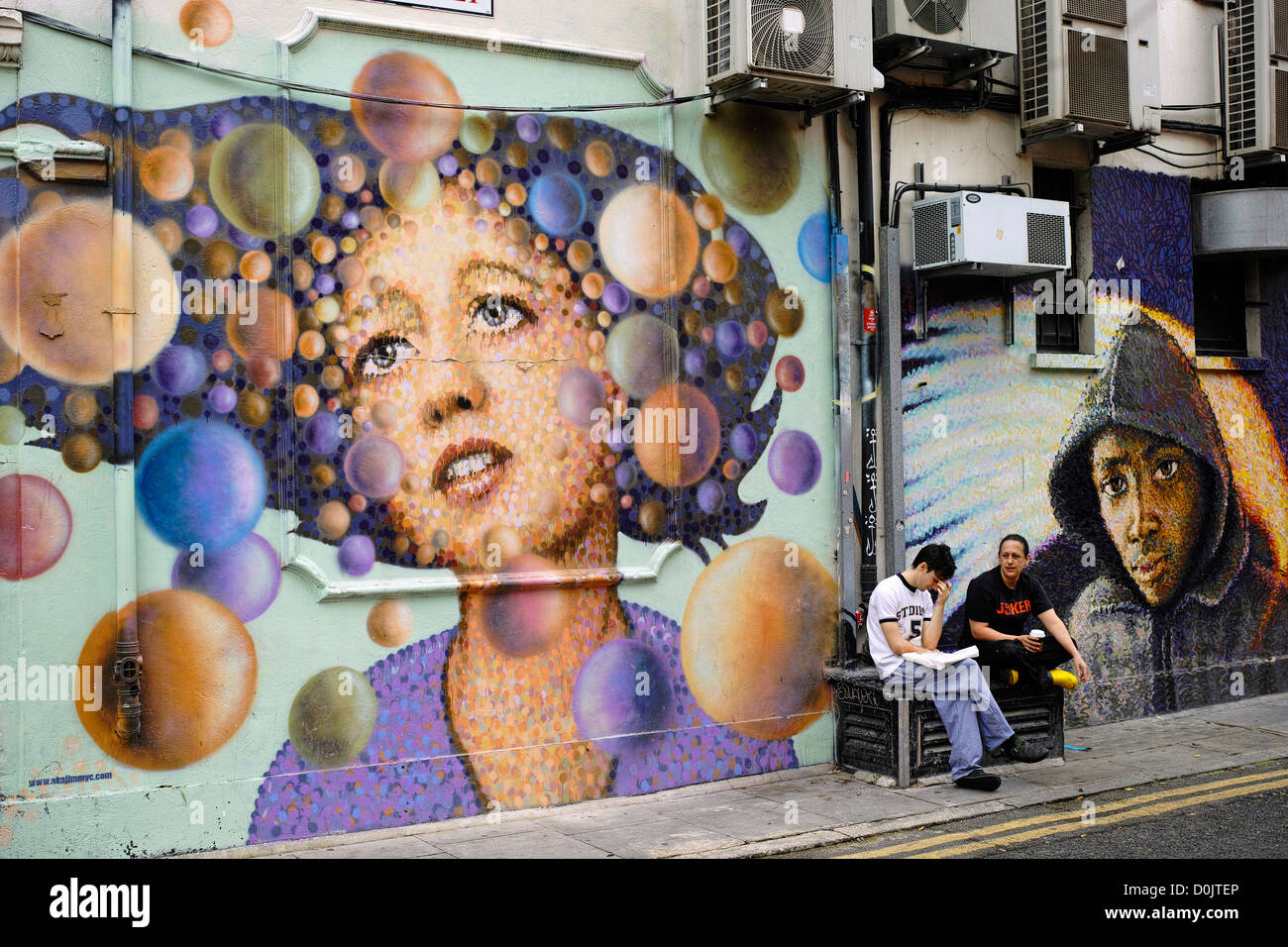 Eine Pause in Whitby Straße vor einer Wandmalerei von James Cochran. Stockfoto