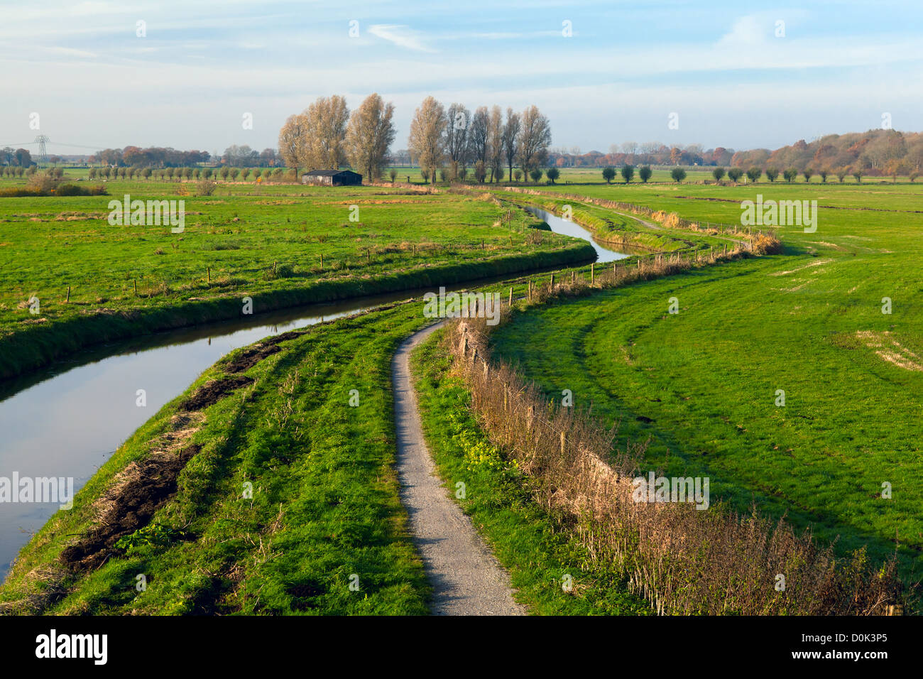 gebogene Fluss unter niederländischen grünen Weiden Stockfoto