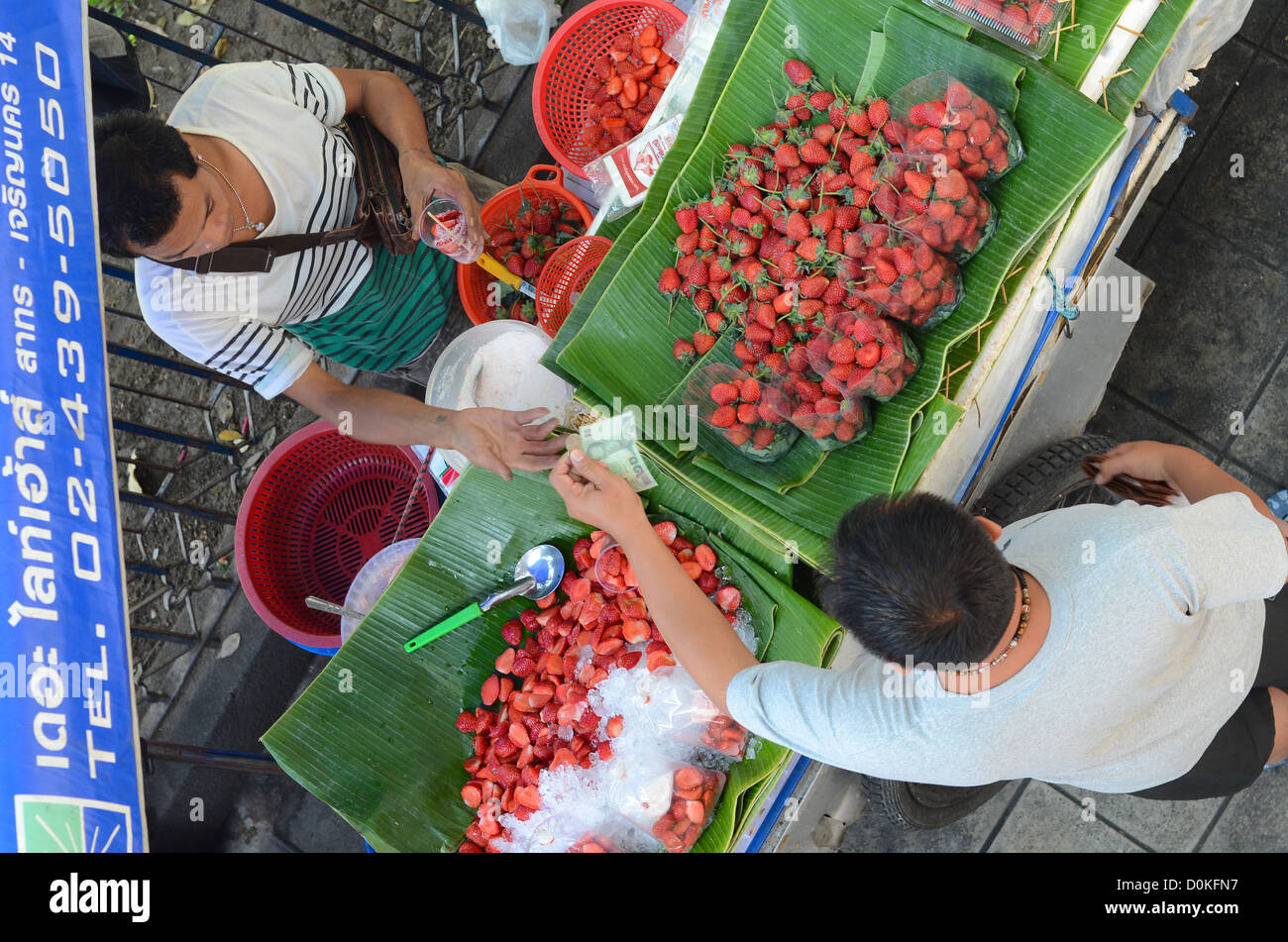 Ein Shopper kaufen Erdbeeren am Chatuchak-Markt in Bangkok, Thailand. Stockfoto