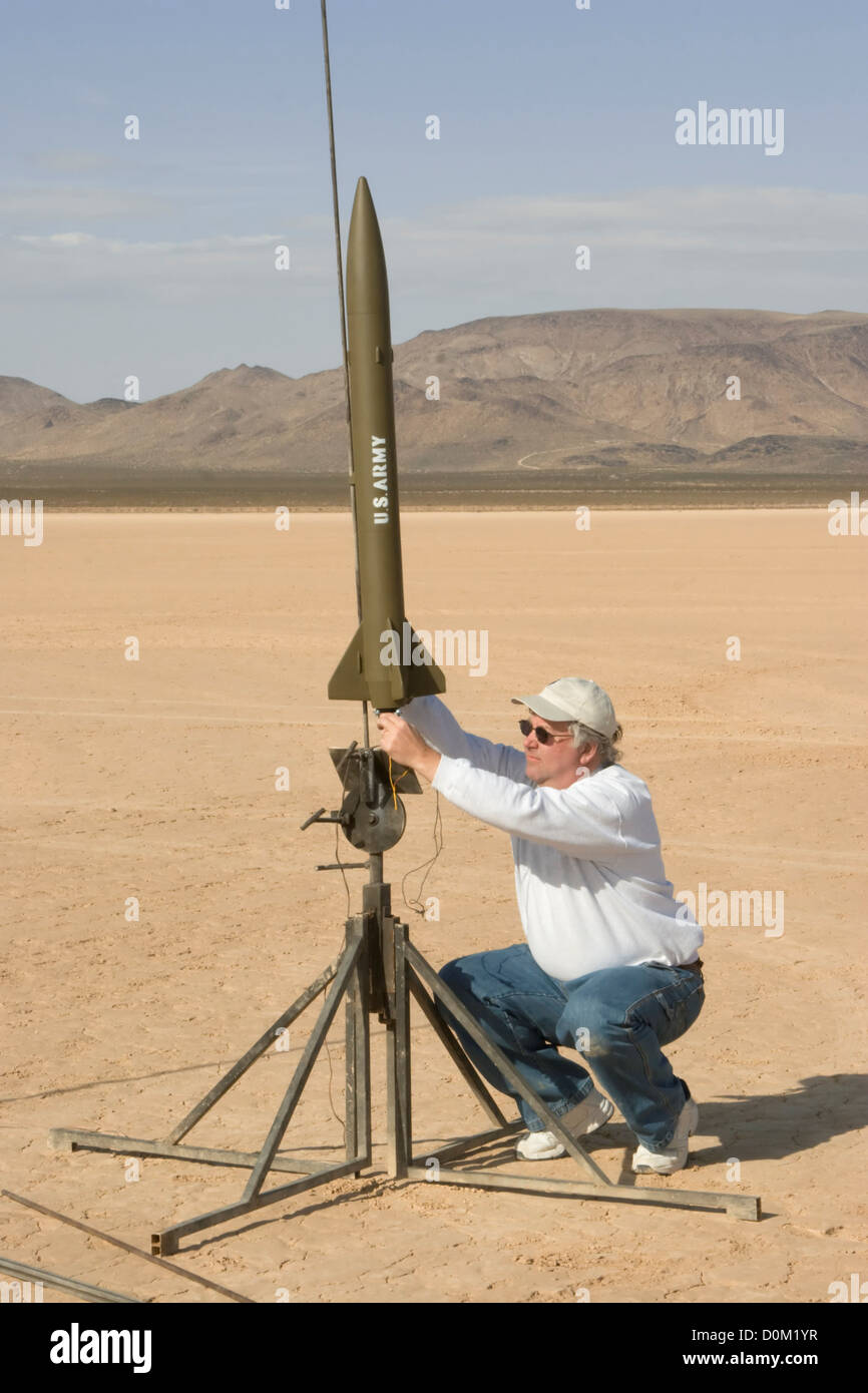Ein Mann bereitet sich auf ein Modell einer Little John-Rakete am Springfest in Nevadas Jean Dry Lake starten. Stockfoto
