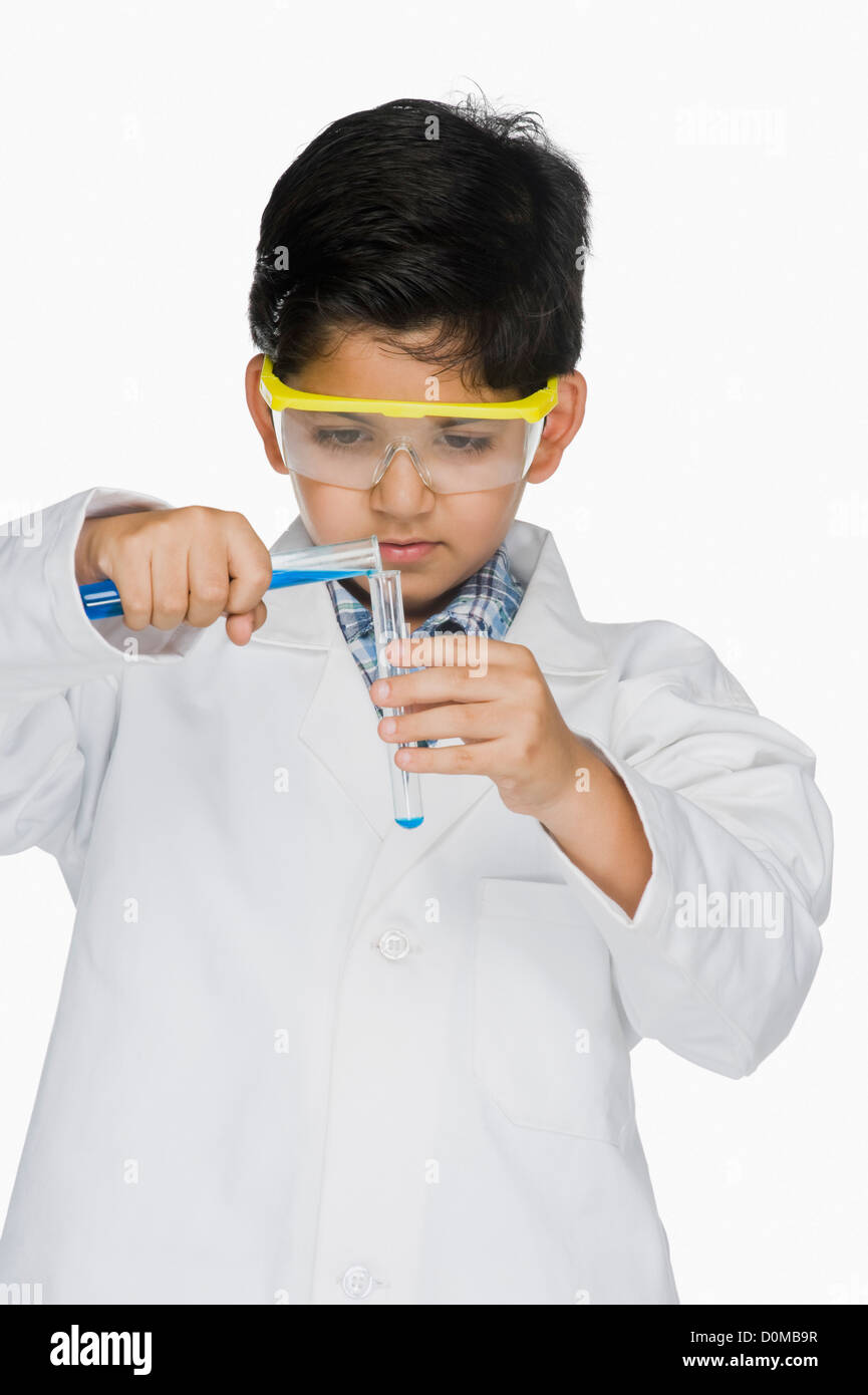 Junge in einem Laborkittel experimentieren mit Reagenzgläsern Stockfoto