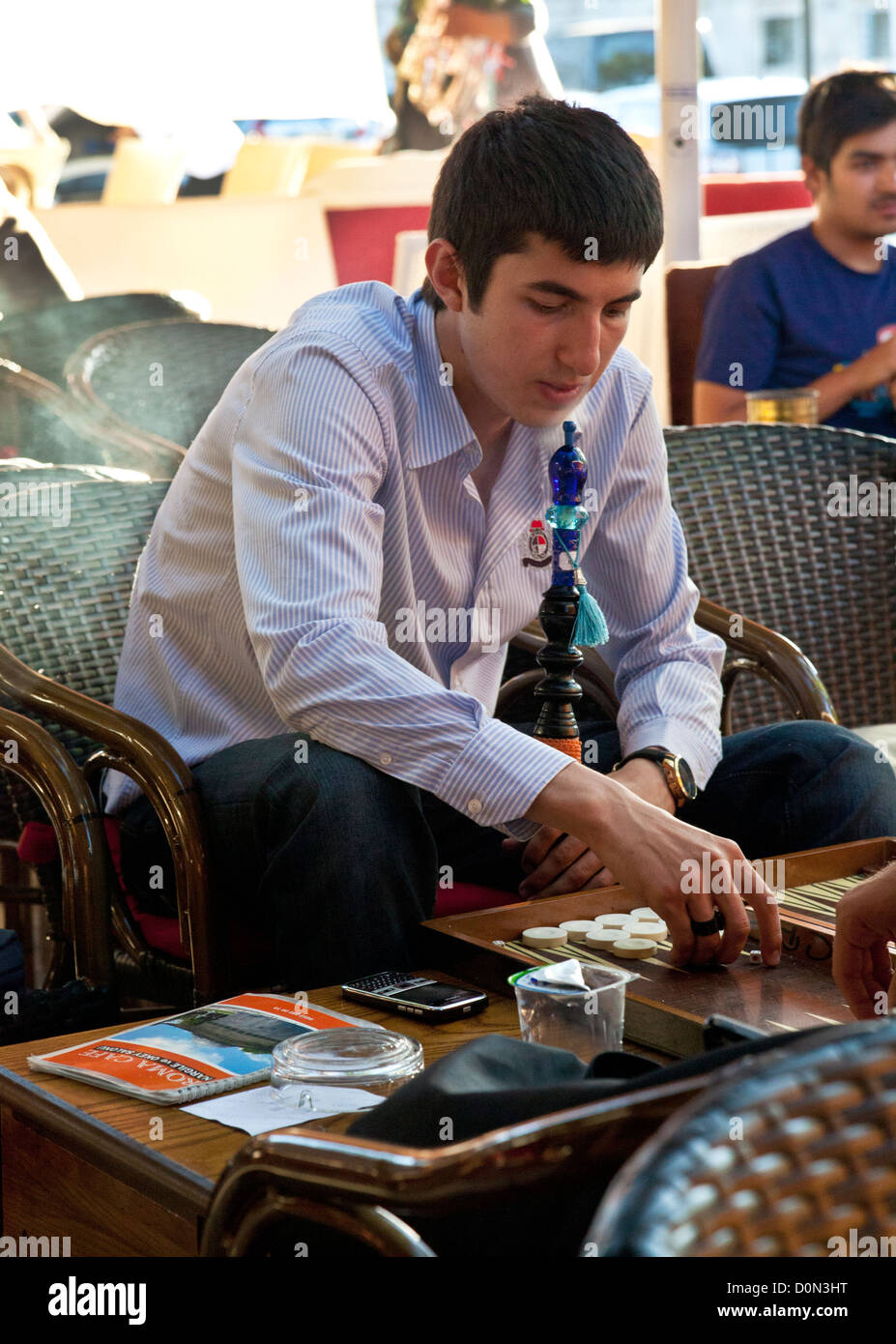 Ein Mann, Backgammon spielen, während das Rauchen einer Shisha/Nargile Rohr in einem Café in Istanbul, Türkei. Stockfoto