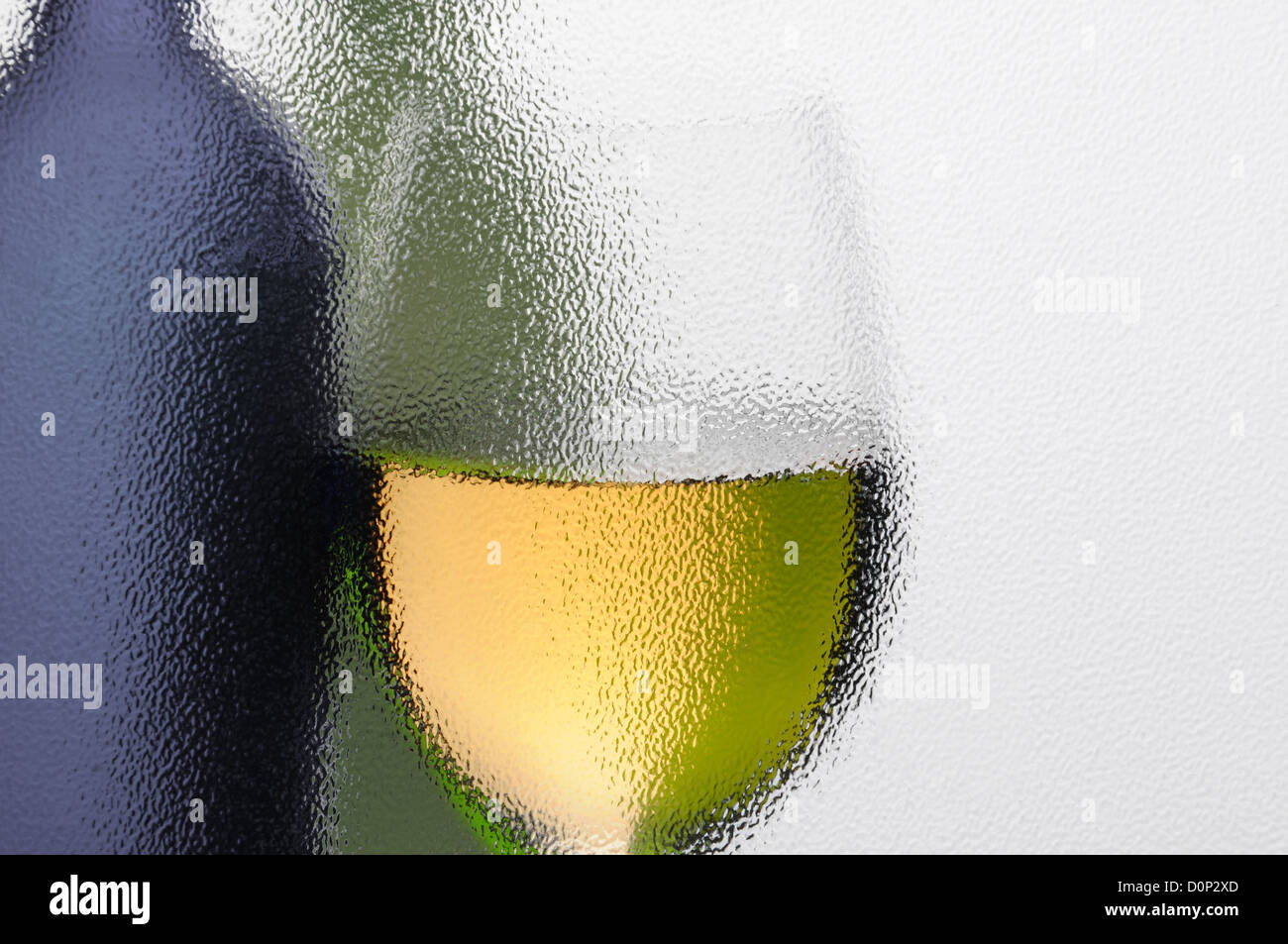 Eine abstrakte Aufnahme von einem Glas Wein und Weinflaschen, die durch ein strukturiertes Fenster gesehen. Querformat mit Textfreiraum. Stockfoto