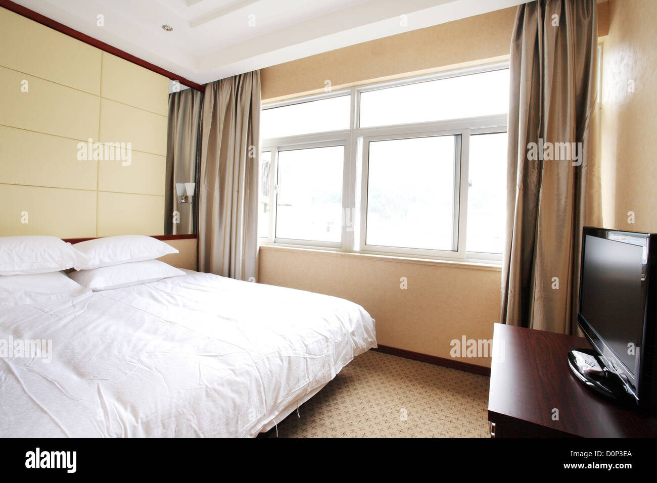 Ein Bett in einem Zimmer mit hellem Licht Stockfoto