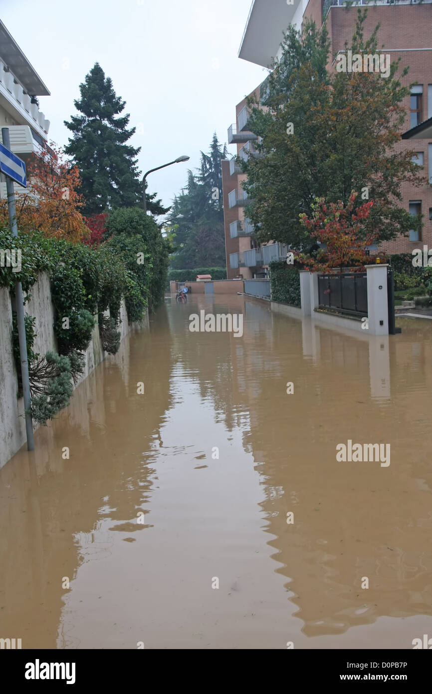 Straße komplett überflutet, während ein Platzregen in der Stadt mit Wohnblocks auf beiden Seiten Stockfoto