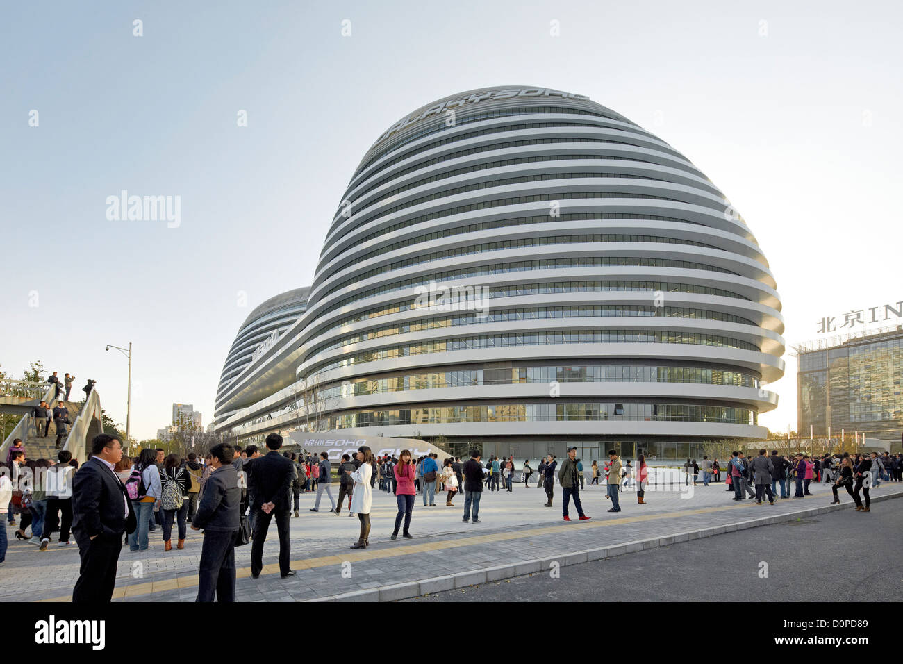Galaxy-Soho, Peking, China. Architekt: Zaha Hadid Architects, 2012. Straßenszene mit Kuppeln im Hintergrund gedrängt. Stockfoto